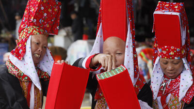 Phụ nữ Dao Thanh Phán ở Bình Liêu thường đội một chiếc mũ màu đỏ giống như cái hộp trên đầu, rồi chùm lên một chiếc khăn cũng màu đỏ có họa tiết hoa văn sặc sỡ