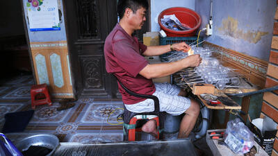 Anh Lê Văn Tuấn với thâm niên vài chục năm với nghề thổi thủy tinh vẫn hàng ngày ngồi 8 tiếng miệt mài