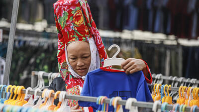 Phụ nữ Dao Thanh phán đi chợ mua quần áo cho con cái